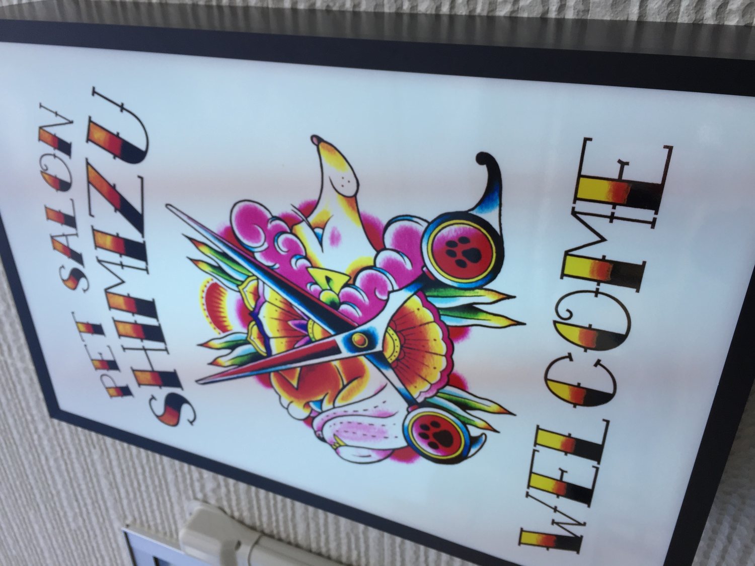 ハサミのイラストを配したペットサロンSHIMIZUの看板