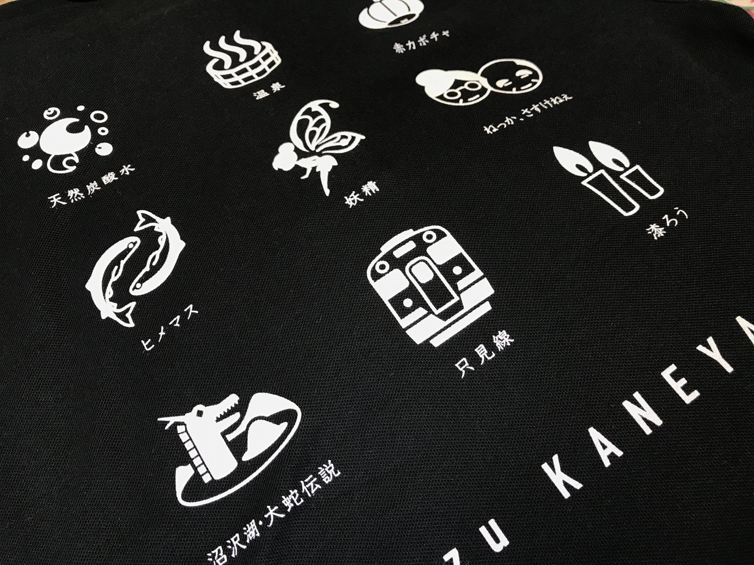 青いカタカナロゴを胸にプリントした白のオリジナルTシャツ