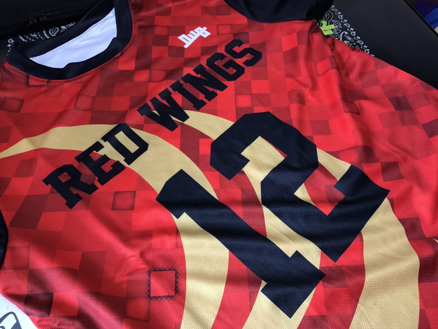 「RED WINGS 12」をプリントした赤いピクセル柄のユニフォーム